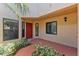 Welcoming front porch with a bright red door and surrounding green landscaping at 7856 Sugar Bend Dr # 7856, Orlando, FL 32819