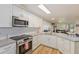 Modern kitchen featuring stainless steel appliances and sleek white cabinetry at 7856 Sugar Bend Dr # 7856, Orlando, FL 32819