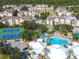 Aerial view of a community featuring a clubhouse, tennis courts, pool, lush landscaping, and residential buildings at 8023 King Palm Cir, Kissimmee, FL 34747