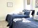 Cozy bedroom featuring two twin beds with navy blue quilts and stylish decor for a relaxing atmosphere at 8023 King Palm Cir, Kissimmee, FL 34747
