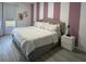 Bedroom featuring modern striped accent wall, large bed, and matching white nightstands at 8023 King Palm Cir, Kissimmee, FL 34747
