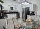 Well-equipped kitchen with stainless steel appliances, black counters and adjacent glass table at 8023 King Palm Cir, Kissimmee, FL 34747