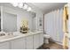 Bathroom with a double sink vanity, decorative mirrors, and neutral colored shower curtain at 8852 Fort Jefferson Blvd, Orlando, FL 32822