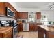 Well-equipped kitchen featuring stainless steel appliances, wood cabinets, and tile backsplash at 8852 Fort Jefferson Blvd, Orlando, FL 32822