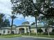 Stately community clubhouse featuring lush landscaping, palm trees, covered entry and ample parking at 8929 Legacy Ct # 208, Kissimmee, FL 34747