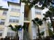 Condo building with stairs, palm trees, and a handicap parking sign in front at 8929 Legacy Ct # 208, Kissimmee, FL 34747