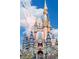 Majestic Cinderella Castle adorned with turrets, spires, and a 50th anniversary emblem against a blue sky at 1168 Citrus Landings Blvd, Davenport, FL 33837