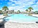 Resort-style community pool with palm trees, comfortable lounge chairs, and beautifully maintained landscaping at 1168 Citrus Landings Blvd, Davenport, FL 33837