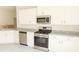 Well-equipped kitchen with stainless steel appliances, granite countertops, and white cabinets at 1168 Citrus Landings Blvd, Davenport, FL 33837