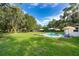 Lush backyard featuring a sparkling pool, inviting patio, and mature trees providing shade and tranquility at 1206 Culver Rd, Orlando, FL 32825