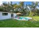 A refreshing swimming pool surrounded by lush greenery and umbrellas in a spacious backyard for outdoor enjoyment at 1206 Culver Rd, Orlando, FL 32825