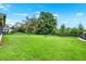 Large backyard is fenced in, with green grass and trees at 1709 Kinsman Way, Lakeland, FL 33809
