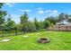 Spacious backyard featuring lush greenery and a charming fire pit at 1709 Kinsman Way, Lakeland, FL 33809