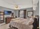 Comfortable bedroom with a ceiling fan, television, and dresser with decorative mirror at 1709 Kinsman Way, Lakeland, FL 33809