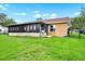 Exterior view of the home and enclosed patio overlooking lush green yard at 1709 Kinsman Way, Lakeland, FL 33809