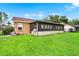Home exterior with a screened patio and a large yard at 1709 Kinsman Way, Lakeland, FL 33809