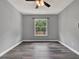 A well-lit, empty bedroom with a ceiling fan and a large window overlooking the fenced backyard at 1712 Riveredge Rd, Oviedo, FL 32766