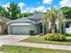 Well-maintained home with a two-car garage, green lawn, and mature trees offering curb appeal at 1712 Riveredge Rd, Oviedo, FL 32766