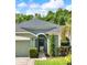 Close-up of home showcasing the front entry with an arched doorway and manicured landscaping at 1712 Riveredge Rd, Oviedo, FL 32766