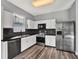 A well-lit kitchen with stainless steel appliances, wood-look floors, and white cabinets at 1712 Riveredge Rd, Oviedo, FL 32766