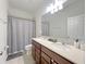 Bright bathroom with a double sink vanity, large mirror, and a shower-tub combo at 17504 Butterfly Pea Ct, Clermont, FL 34714