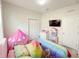 Vibrant bedroom featuring a colorful bed, play tent, and TV at 17504 Butterfly Pea Ct, Clermont, FL 34714