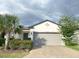Charming single-story home featuring a well-maintained lawn and attached two-car garage with a brick-paved driveway at 17504 Butterfly Pea Ct, Clermont, FL 34714