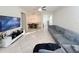 Open-concept living room with tile floors, ceiling fan, grey sofa, and TV at 17504 Butterfly Pea Ct, Clermont, FL 34714