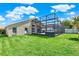 Landscaped backyard with a screened in patio with a hot tub at 211 Tavestock Loop, Winter Springs, FL 32708