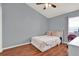 Cozy bedroom with light blue walls, wood floors, and a comfortable bed at 211 Tavestock Loop, Winter Springs, FL 32708
