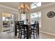 Cozy dining area featuring a chandelier, modern table set, and sliding glass doors to a screened lanai at 211 Tavestock Loop, Winter Springs, FL 32708
