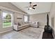 Inviting living room with a large sectional sofa, ceiling fan, and windows offering backyard views at 211 Tavestock Loop, Winter Springs, FL 32708