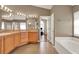 Well-lit primary bathroom with double vanity, tub, and walk in shower at 211 Tavestock Loop, Winter Springs, FL 32708