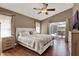 Relaxing primary bedroom with hard wood floors, ceiling fan, and sliding glass doors to the lanai at 211 Tavestock Loop, Winter Springs, FL 32708