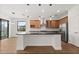 Bright open-concept kitchen features a granite island, modern pendant lighting, and stainless steel appliances at 212 Lugano Way, Debary, FL 32713