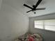 A simple bedroom with white walls, a ceiling fan, a window with blinds, and a comfy bed at 223 Hope Cir, Orlando, FL 32811