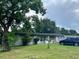 Inviting single-story home with lush landscaping, mature trees, and a car parked on the side at 223 Hope Cir, Orlando, FL 32811
