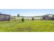 Expansive backyard with lush green grass, a fenced perimeter, and serene lake views at 2254 Canyon Breeze Ave, Kissimmee, FL 34746