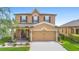 Charming two-story home with a well-manicured lawn, landscaping and a covered porch with swing at 2254 Canyon Breeze Ave, Kissimmee, FL 34746