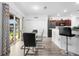 Open dining area with a glass table, modern chairs, barstools, and access to the kitchen and outdoor patio at 2254 Canyon Breeze Ave, Kissimmee, FL 34746