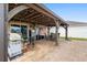 Outdoor covered kitchen includes a built-in grill, dining furniture and an American flag at 2254 Canyon Breeze Ave, Kissimmee, FL 34746