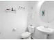 Bright powder room with white walls, pedestal sink, and decorative wall decor at 2254 Canyon Breeze Ave, Kissimmee, FL 34746