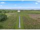 A long wooden dock stretches through a green marsh toward the water, offering stunning views at 2921 Lake Tohopekaliga Blvd, Kissimmee, FL 34746