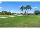 Wide-open property featuring a charming house, a brick-paved driveway, lush lawn, and tall palm trees at 2921 Lake Tohopekaliga Blvd, Kissimmee, FL 34746
