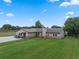 Charming single-story home with lush lawn, stone accents, and a spacious driveway under a bright blue sky at 2921 Lake Tohopekaliga Blvd, Kissimmee, FL 34746