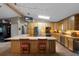 Bright kitchen with wood cabinets, granite countertops, stainless steel appliances, and bar seating at 2921 Lake Tohopekaliga Blvd, Kissimmee, FL 34746