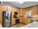 Bright kitchen with stainless steel appliances, wooden cabinets, and tile backsplash at 2921 Lake Tohopekaliga Blvd, Kissimmee, FL 34746