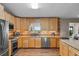 Well-lit kitchen featuring wood cabinets, stainless steel appliances, tile backsplash, and a window view at 2921 Lake Tohopekaliga Blvd, Kissimmee, FL 34746