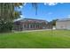 A screened-in pool area with a brick-paved deck surrounded by lush landscaping at 2921 Lake Tohopekaliga Blvd, Kissimmee, FL 34746