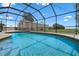 Sparkling pool surrounded by a screened enclosure offering relaxing views of the yard at 2921 Lake Tohopekaliga Blvd, Kissimmee, FL 34746